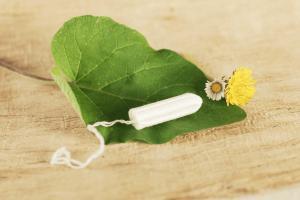 Bio-Tampon aus Baumwolle auf Blatt mit Blume