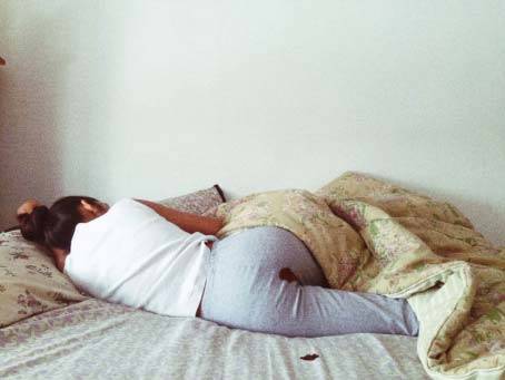 Rupi Kaur Bild einer Frau im Bett mit Blutfleck