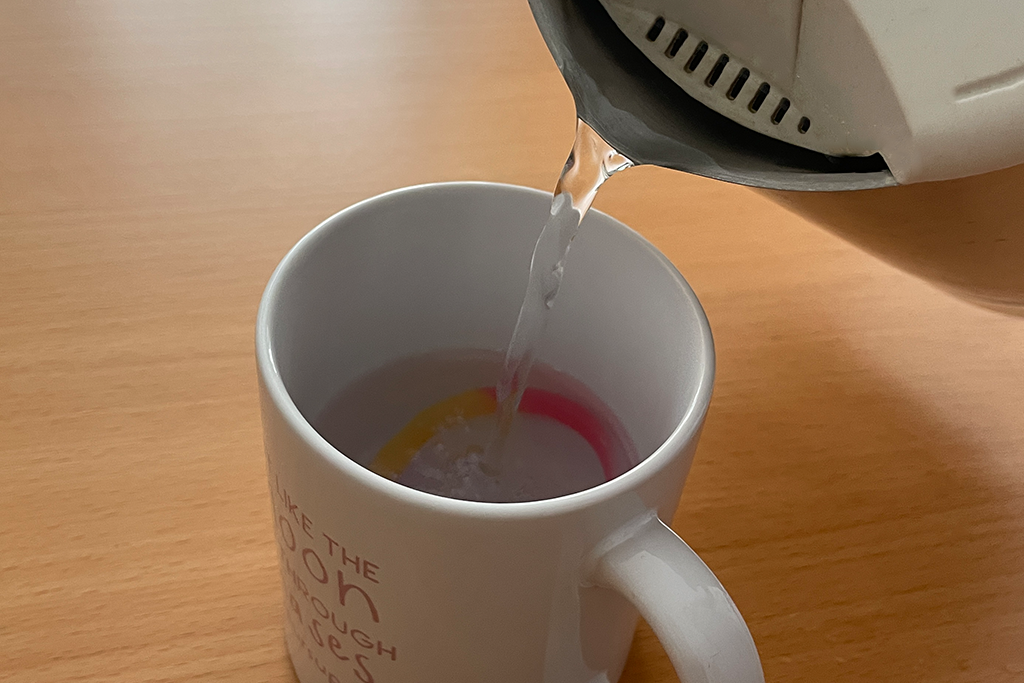 Menstrual disc wird in einer Tasse mit kochendem Wasser sterilisiert