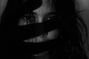 Schwarz/weiß Foto von Frau, die Hand vor das Gesicht hält